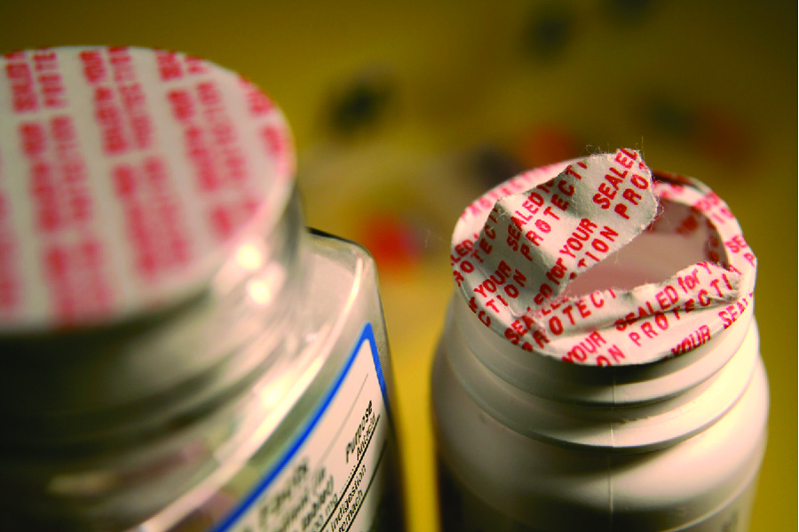 A photograph shows two pill bottles covered with tamper-proof seals; one seal is intact and one seal is broken.