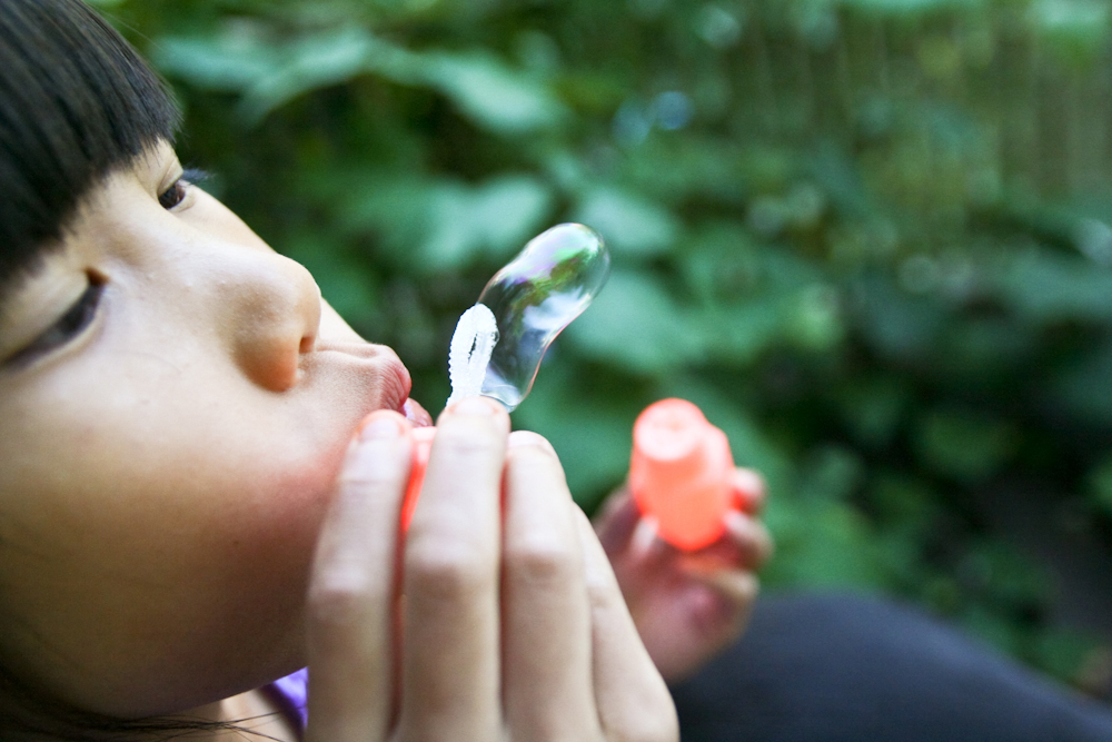 The soap bubbles that the child blows into the air maintain their shape because of the attractive force between the molecules of the soap bubble.